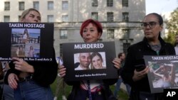 民眾手舉被巴勒斯坦武裝分子殺害和劫為人質的以色列婦女與兒童的照片在倫敦的英國首相官邸唐寧街10號外舉行支持以色列的集會。（2023年10月9日）