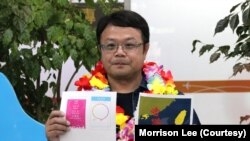 李孟居9月2日在台灣機場出示他四年前遭捕時，被中國海關視為謀反證據的小卡圖樣，包括為空服員打氣的“愛與和平”小卡及“香港加油”小卡（美國之音特約記者李賢攝影）。