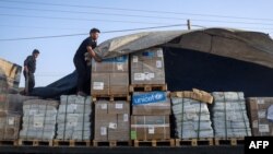 Маж истоварува хуманитарна помош од камиони кои влегуваат во Газа од Египет преку граничниот премин Рафах, 21 октомври 2023 година