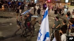 Israeli police remove a person protesting against Israeli Prime Minister Benjamin Netanyahu's government as demonstrators call for the release of hostages held in the Gaza Strip by the Hamas militant group, in Tel Aviv, Israel, June 1, 2024.