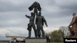 Un monumento soviético a la amistad entre las naciones ucraniana y rusa se ve antes de su demolición, en el centro de Kiev, Ucrania, el 26 de abril de 2022.
