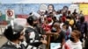 Migrantes hacen cola junto a miembros de la Guardia Nacional, para ser procesados por visas humanitarias para continuar su viaje hacia Estados Unidos, afuera de la oficina del Instituto Nacional de Migración (INM) en Tapachula, México, el 24 de febrero de 2022.