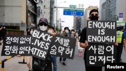 FILE - People march on the street in solidarity with protests against the death in Minneapolis police custody of George Floyd, in Seoul, South Korea, June 6, 2020.
