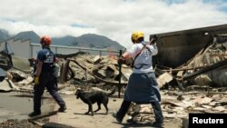 Socorristas con perros registran las ruinas de los edificios destruidos en Lahaina, en Maui, Hawái, el 13 de agosto de 2023.