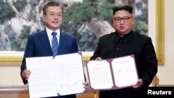 문재인 한국 대통령과 김정은 북한 국무위원장이 19일 평양 백화원 영빈관에서 평양공동선언문에 서명한 후 합의서를 들어보이고 있다. 사진 출처=평양사진공동취재단