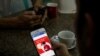 Seorang pengguna ponsel melihat halaman Facebook di sebuah toko di jalan Latha, Yangon, Myanmar, 8 Agustus 2018. (Foto: REUTERS/Ann Wang)