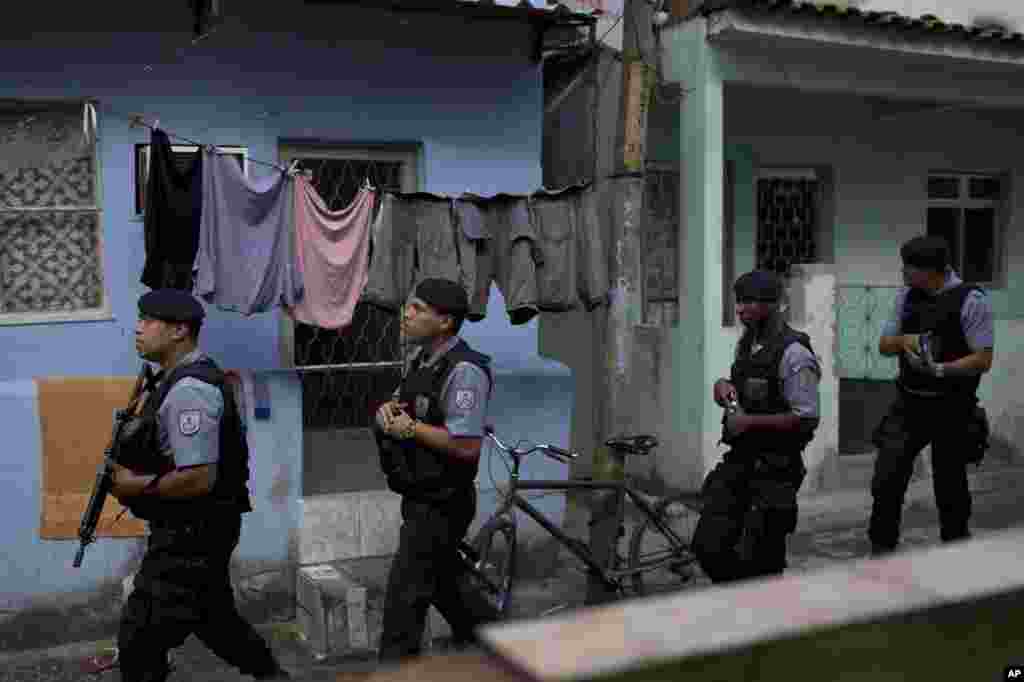 Policías de la Unidad de Pacificación (UPP) patrulla el área de Varginha en el complejo de la favela Manguinhos como parte de la seguridad por la visita del Papa.