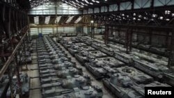 Dozens of German-made Leopard 1 tanks and other armoured vehicles are seen in an hangar in Tournais
