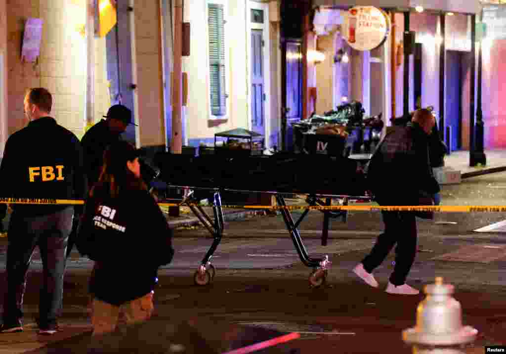 People carry a dead body in a body bag on a stretcher near the site where people were killed by a man driving a truck in an attack during New Year's celebrations, in New Orleans, Louisiana, Jan. 2, 2025. 