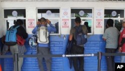 ARCHIVO - Migrantes de El Salvador esperan ser atendidos por las autoridades migratorias salvadoreñas en La Hachadura, El Salvador, el miércoles 31 de octubre de 2018. [Foto: AP]