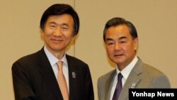 윤병세 한국 외교부 장관(왼쪽)이 8일 미얀마 네피도 국제 컨벤션 센터에서 열린 한ㆍ중 양자회담에서 왕이 중국 외교부장과 악수하고 있다.