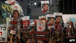 Demonstranti u Tel Avivu drže transparente sa fotografijama izraelskih talaca (Foto: AHMAD GHARABLI / AFP)