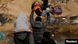 Karen, una migrante de 4 años, es levantada sobre las aguas del Río Bravo en su intento de llegar desde México a la frontera de Estados Unidos, el 2 de enero de 2024. Las autoridades mexicanas tratan de ubicar y liberar a un grupo de 31 migrantes secuestrados en Tamaulipas.