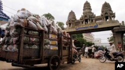 រូបឯកសារ៖ ពលករ​ខ្មែរ​ដឹក​ឥវ៉ាន់​របស់​ពួកគេ​ចេញ​ពី​ប្រទេស​ថៃ នៅ​ឯ​ច្រក​​ព្រំដែន​អន្តរជាតិ​កម្ពុជា​-ថៃ នៅ​ក្រុង​ប៉ោយប៉ែត ​ថ្ងៃទី​១៨ ខែមិថុនា ឆ្នាំ​២០១៤។ (AP) 