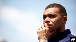 ARCHIVO - El delantero francés Kylian Mbappé escucha al técnico Didier Deschamps en la ciudad deportiva de la selección nacional con miras a la Euro 2024, el 3 de junio de 2024, en Clairefontaine.