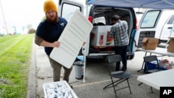 Des Moines Area Religious Council Food Pantry worker Patrick Minor looks over a cooler full of ground pork packages during a pantry stop, Wednesday, May 20, 2020, in Des Moines, Iowa. (AP Photo/Charlie Neibergall) 