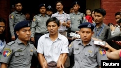 Kyaw Soe Oo et Wa Lone quittant sous bonne escorte policière le tribunal à Rangoun, Birmanie, le 20 août 2018. 