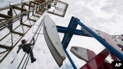 Робітник на устаткуванні з видобутку сланцевої нафти в США 