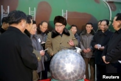 김정은 북한 국방위원회 제1위원장이 핵무기 연구 부문 과학자, 기술자들을 만나 핵무기 병기화 사업을 지도하는 모습을 조선중앙통신이 지난 3월 보도했다. 사진 아래쪽에 핵탄두 기폭장치 추정 물체가 보인다.