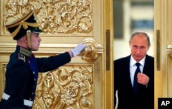 Russian President Vladimir Putin, right, enters the Alexadrovsky Hall to head a meeting of the Presidential Council for Civil Society and Human Rights at the Kremlin in Moscow, Russia, Thursday, Oct. 1, 2015.