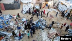 Warga Palestina memeriksa kerusakan di kamp tenda yang menampung orang-orang terlantar, setelah serangan Israel, di tengah konflik Israel-Hamas, di daerah Al-Mawasi, di Khan Younis, Jalur Gaza selatan, 18 Desember 2024. (Hatem Khaled/REUTERS)