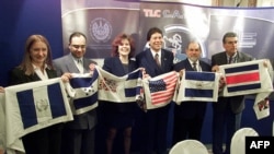 En la foto de archivo, los negociadores del Tratado de Libre Comercio de Centroamérica y Estados Unidos muestran banderas de sus respectivos países, el 4 de Abril de 2003.
