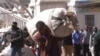 FILE: A vendor carries his goods after he was evicted from the streets by Zimbabwean police in Harare, Wednesday, July, 8, 2015. (AP Photo/Tsvangirayi Mukwazhi)