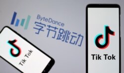 FILE - Tik Tok logos are seen on smartphones in front of a displayed ByteDance logo in this illustration taken Nov. 27, 2019.