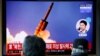 People watch a TV showing a file picture for a news report on North Korea firing two unidentified projectiles, in Seoul, South Korea, March 2, 2020.