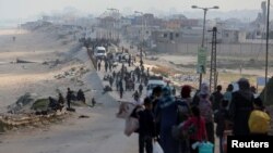 Sejumlah warga Palestina berusaha kembali ke rumah mereka di utara Gaza dengan berjalan melewati pos pemeriksaan Israel di wilayah Gaza tengah pada 15 April 2024. (Foto: Reuters/Ramadan Abed)
