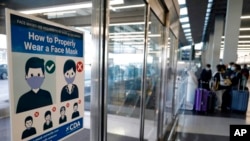 Un cartel en el Aeropuerto Internacional de O'Hare, en Chicago, informa en junio de 2021 a los pasajeros cómo deben usar las máscaras en los aviones.