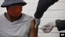 A vaccine volunteer gets an injection at the Chris Hani Baragwanath hospital in Soweto, Johannesburg Wednesday, June 24, 2020. The large-scale trial is being conducted for a vaccine candidate from AstraZeneca and the University of Oxford. (AP Photo/Siphiwe Sibeko)