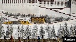 People walk past snow-covered trees outside the Potala Palace in Lhasa, Tibet Autonomous Region, China, Dec. 19, 2018. 