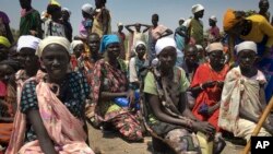 Des femmes sont assises sur le sol en attendant de recevoir de la nourriture distribuée par le Programme alimentaire mondial (PAM) à Padeah, au Sud-Soudan, 1er mars 2017