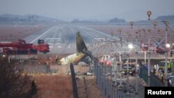 Puing-puing pesawat Jeju Air yang meluncur ke luar landasan pacu dan menabrak dinding tergeletak di Bandara Internasional Muan, di Muan, Korea Selatan, Senin, 30 Desember 2024. (Foto: Kim Hong-ji/Reuters)