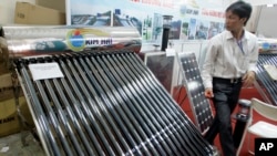 Sebuah pemanas air bertenaga surya (kiri) dan panel surya (kanan) dipamerkan dalam Pameran Entech Hanoi, di Giang Vo Exhibition Center, Hanoi, Vietnam, 18-21Juni 2009. (AP Photo/Chitose Suzuki) 