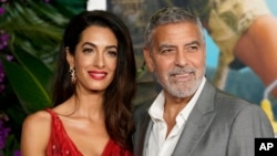 ARCHIVO - George Clooney, a la derecha, y su esposa Amal, asisten al estreno de la película Ticket al Paraíso, el 17 de octubre de 2022, en Los Ángeles. Ambos crearon y dirigen la Fundación Clooney para la Justicia, que investiga crímenes de lesa humanidad en Venezuela.