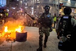 Police clear a road around a fire that was lit during a pro-democracy protest in the Mong Kok district of Hong Kong on May 27, 2020.
