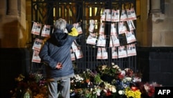 Muškarac u Kelnu posmatra fotografije talaca Hamasa u Izraelu, 8. novembar 2023. (foto AP)