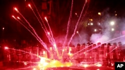 Demonstrators use firecrackers against police during a rally against the government's decision to suspend negotiations on joining the European Union for four years, outside the parliament building in Tbilisi, Georgia, Dec. 1, 2024. 