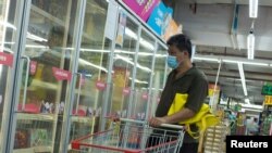 A man looks at frozen food products in a supermarket following an outbreak of the coronavirus disease (COVID-19) in Beijing, China, August 13, 2020.